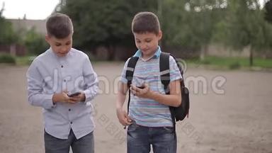 两个男孩<strong>放学</strong>后玩网络游戏。 小男孩微笑，用电话